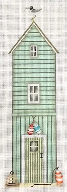 A green house with a snowman hanging from the window.