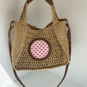A crocheted bag with a red and white pattern on the front.