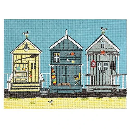 A group of three beach huts on the shore.