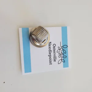 A metal pin sitting on top of a white card.