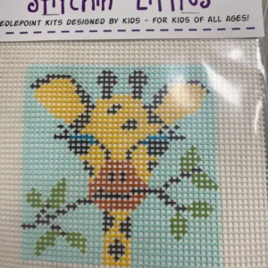 A cross stitch kit of a giraffe with leaves.