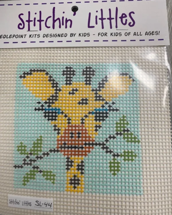 A cross stitch kit of a giraffe with leaves.