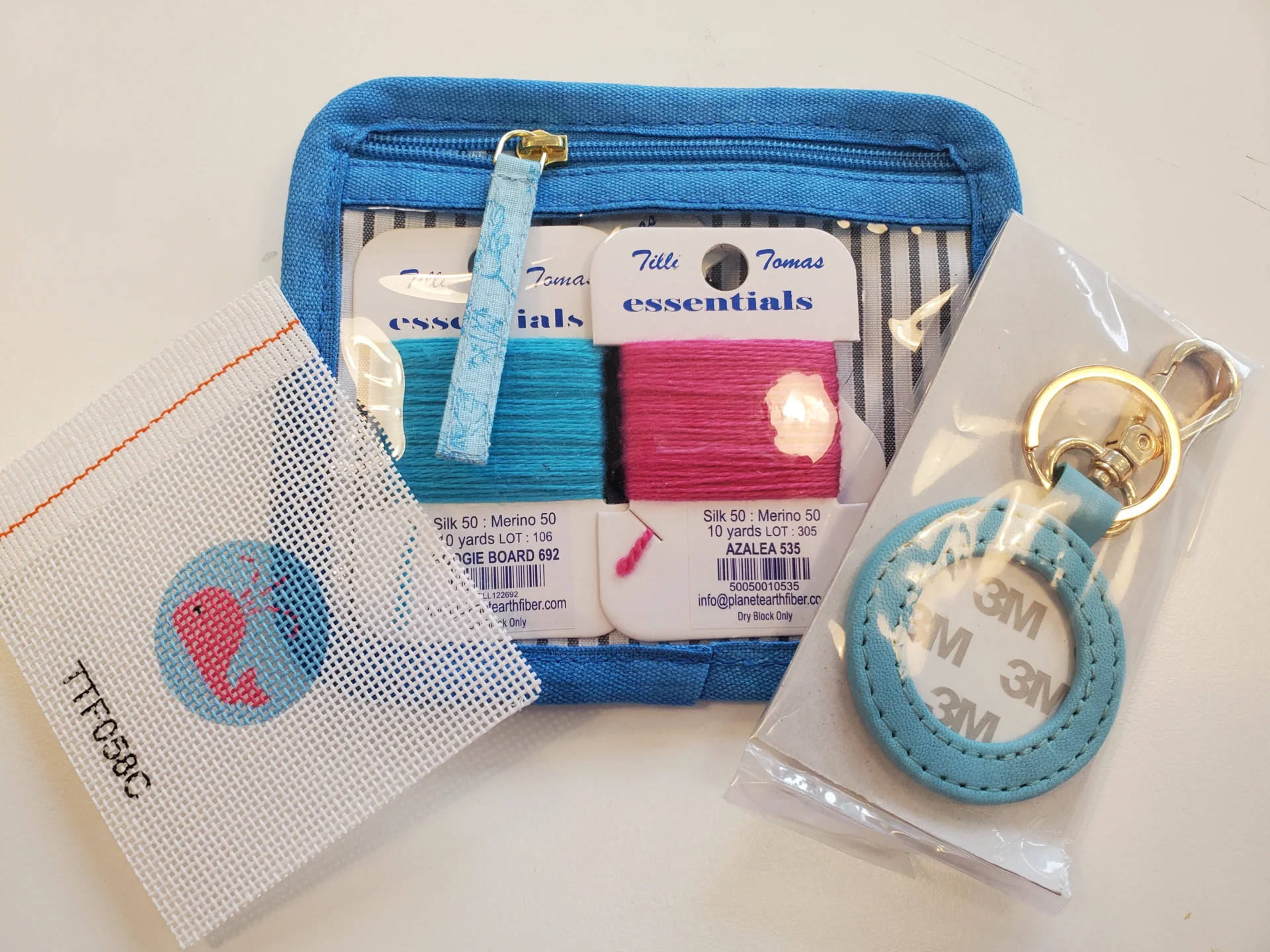 A blue purse with some little bags and a key chain