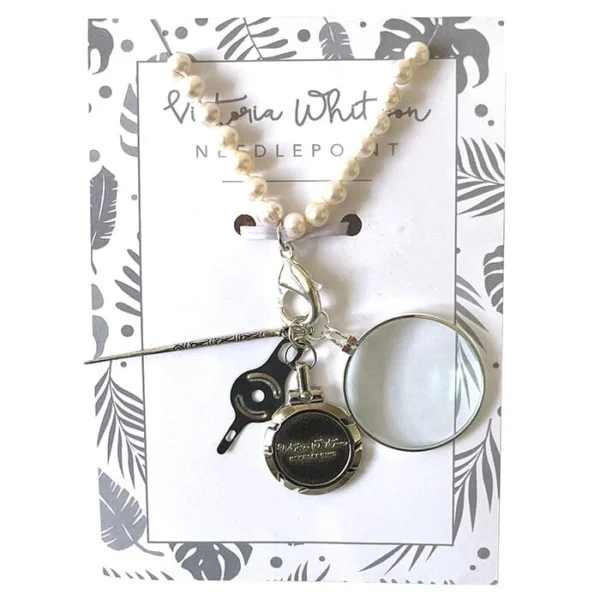 A necklace with a pair of scissors, magnifying glass and key.