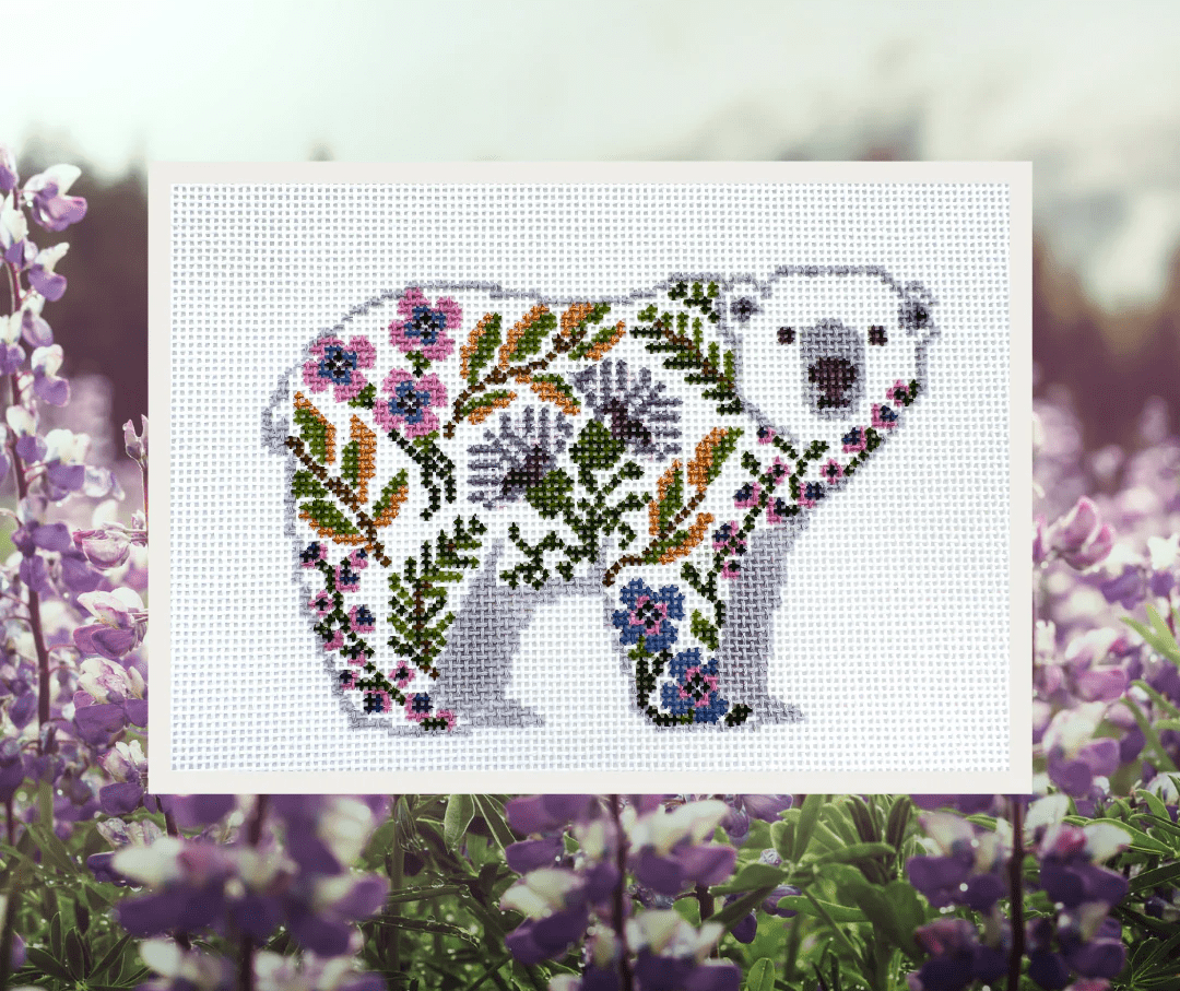 A white bear with purple and pink flowers on it's back.