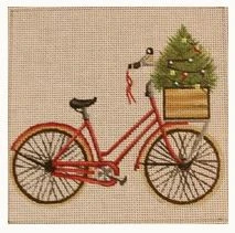 A red bicycle with a christmas tree in the basket.