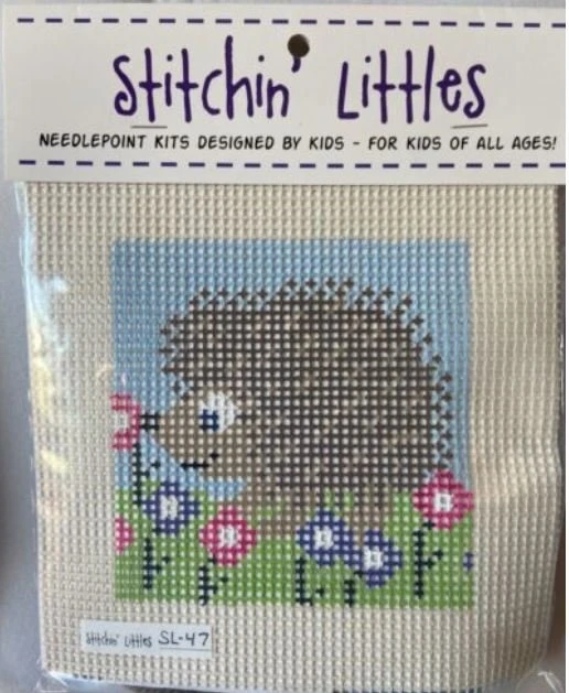 A cross stitch kit of a hedgehog with flowers.