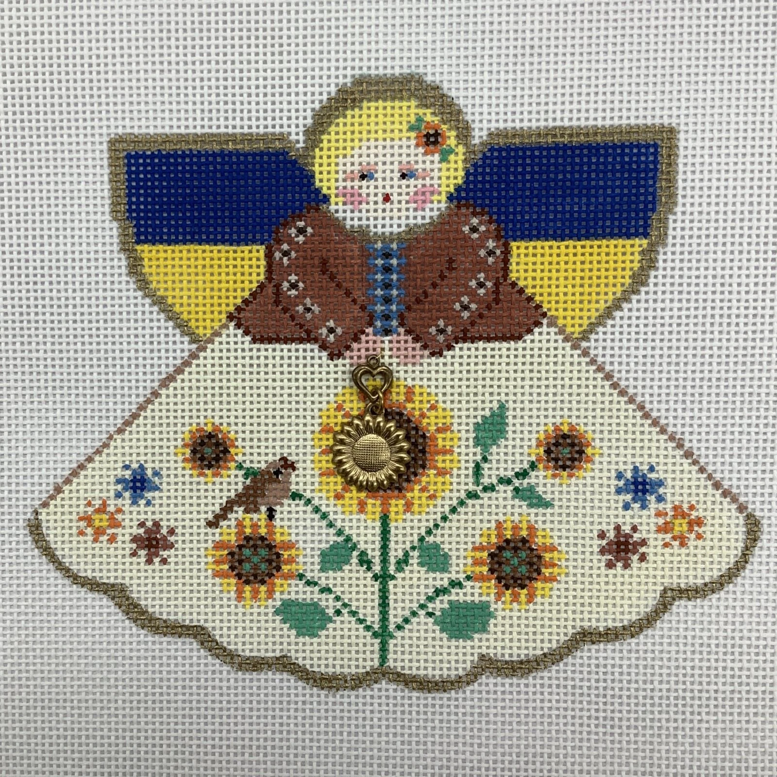 A cross stitch of an angel with flowers.