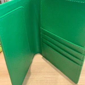 A green wallet sitting on top of a table.