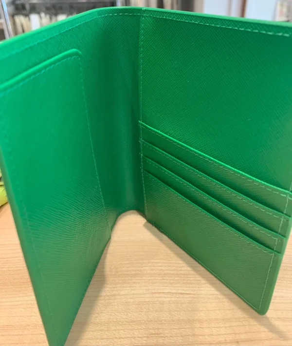 A green wallet sitting on top of a table.