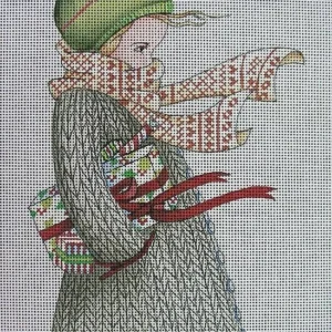 A woman in a sweater and hat holding a gift.