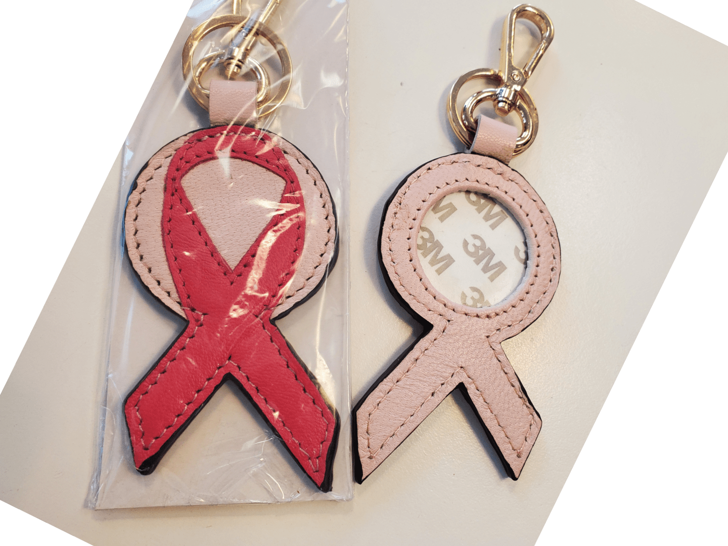 A red ribbon and pink ribbon key chain.