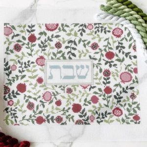 A white table with a floral pattern and a red flower.