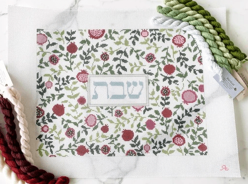 A white table with a floral pattern and a red flower.