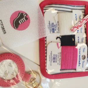 A pink case with some sewing supplies on it