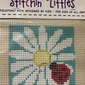 A cross stitch kit with a ladybug and flower.