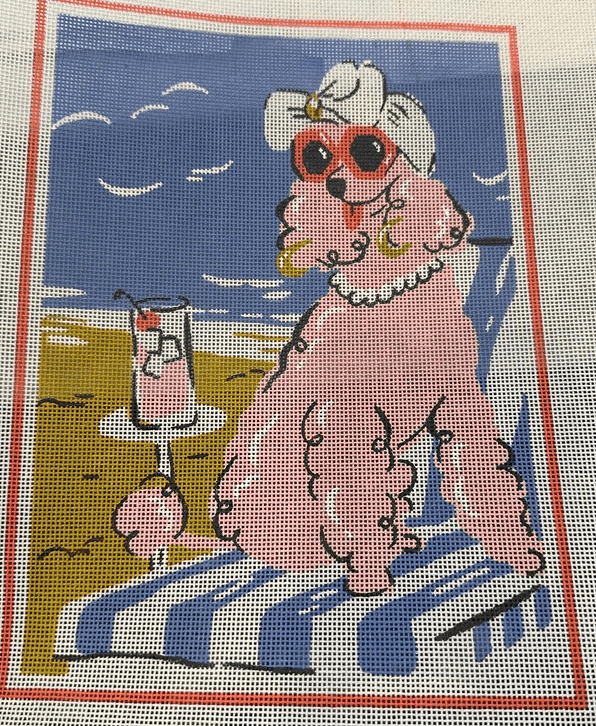 A pink poodle sitting on the beach with a drink.