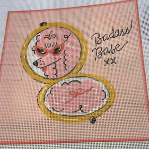 A cross stitch pattern of a pink poodle in an open case.