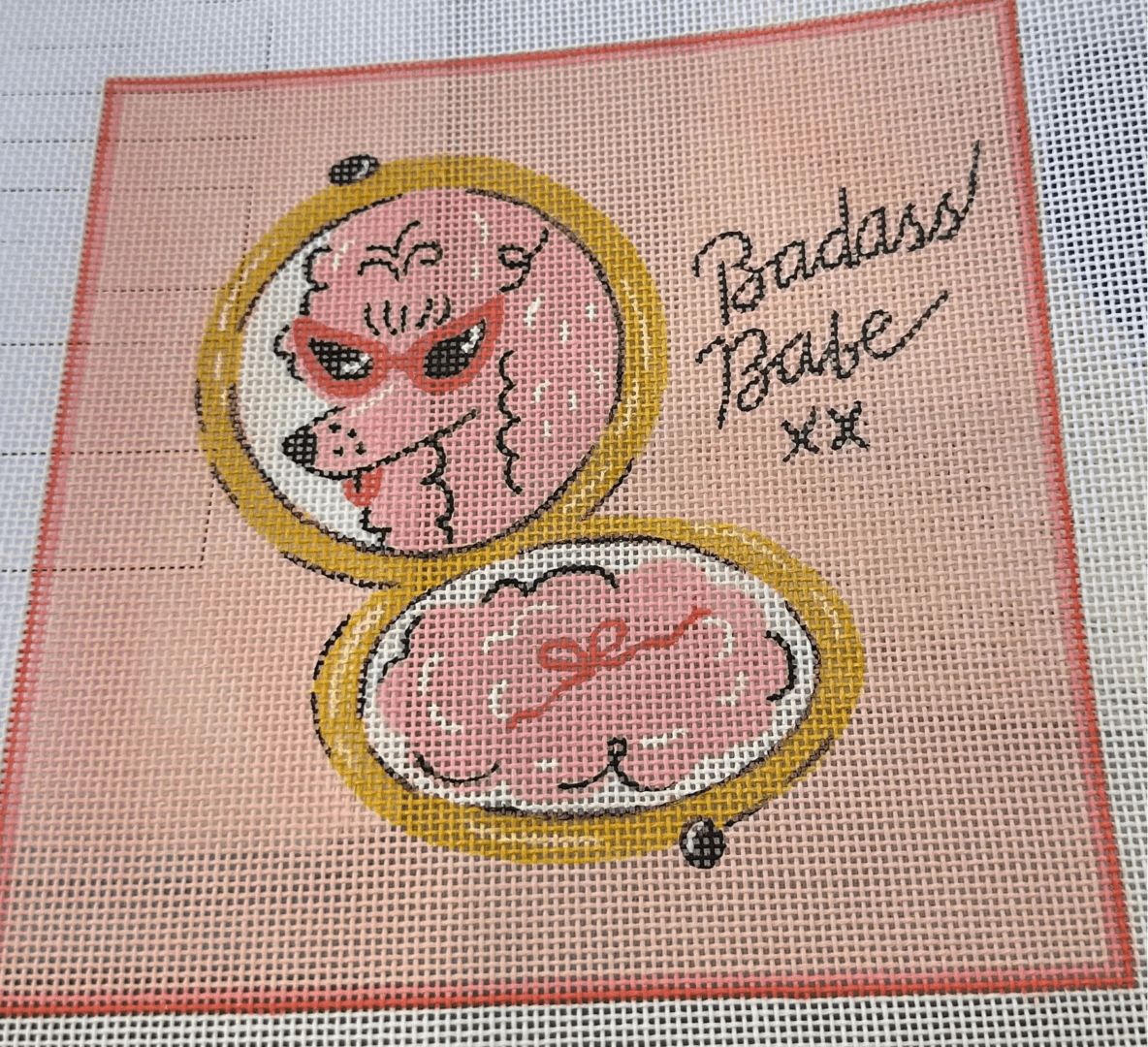 A cross stitch pattern of a pink poodle in an open case.