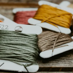 A close up of some different colored thread