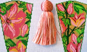 Pink tassel between floral needlepoint panels