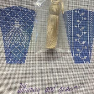 Cream tassel on blue needlepoint canvas