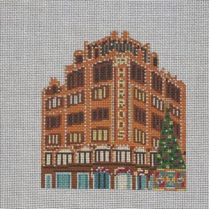 Needlepoint of brick building with Christmas tree