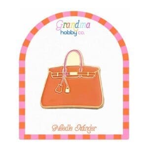 Orange handbag enamel pin on display card